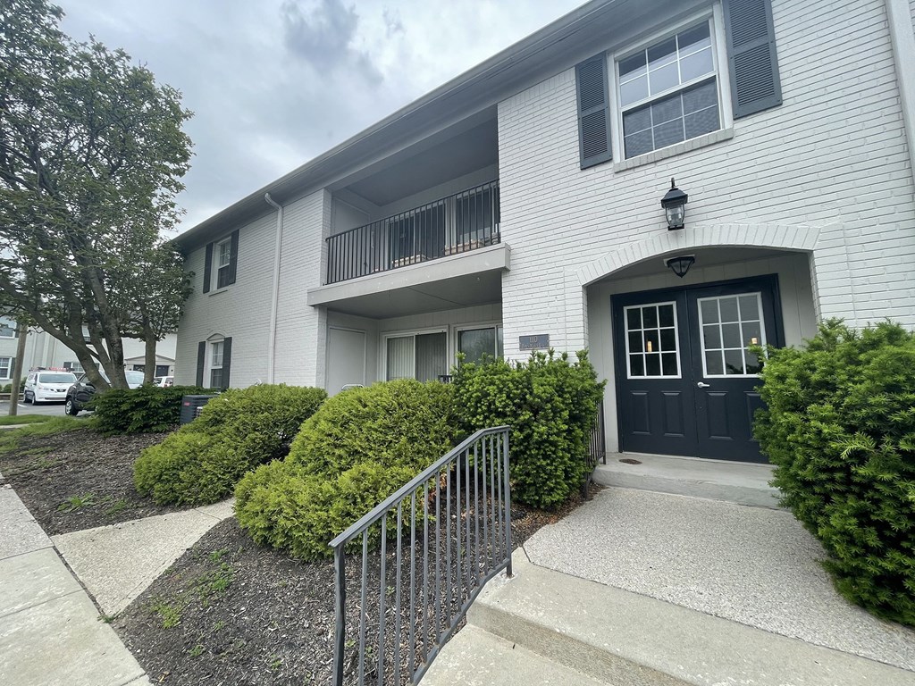 a white apartment building with a black door and white siding