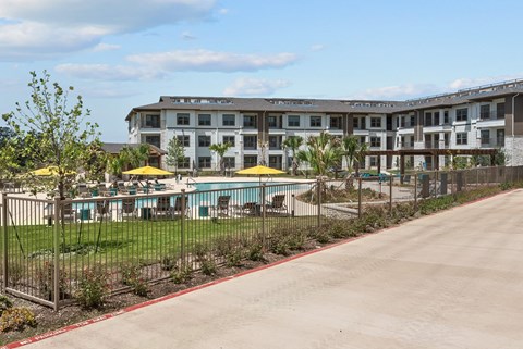 A large building with a pool in front of it.