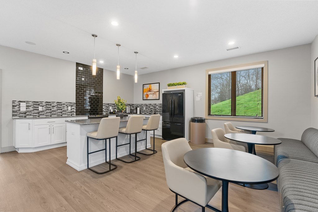 A modern kitchen with a bar area and a dining table.