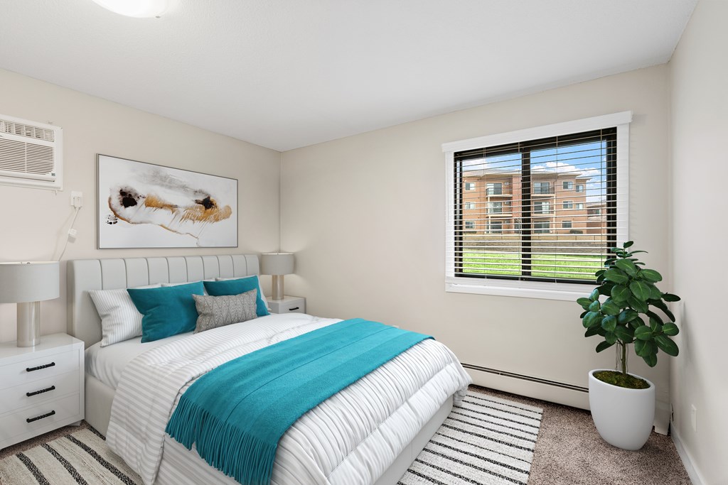 A bedroom with a large bed and a potted plant.
