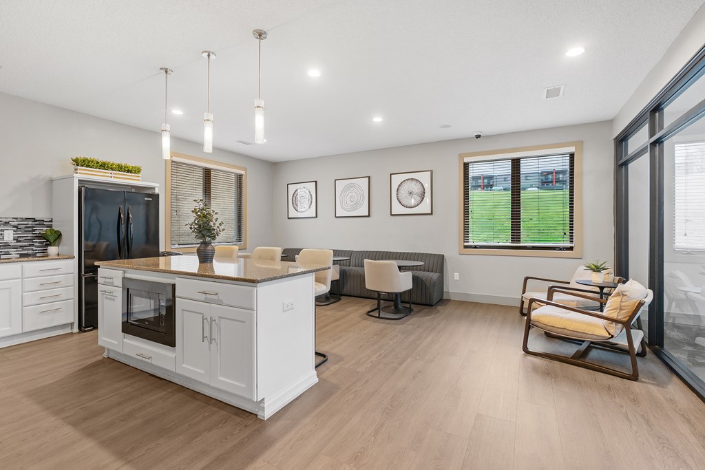 A modern kitchen with a wooden floor and white cabinets.