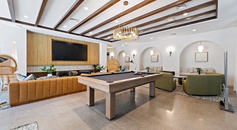 A room with a pool table and a television.