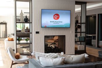 A modern living room with a flat screen TV mounted above a fireplace.