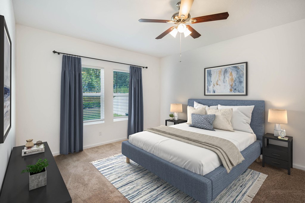 A bedroom with a bed, nightstands, and a ceiling fan.
