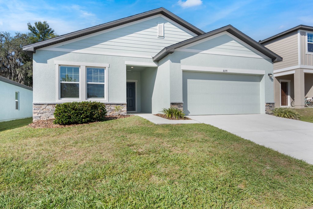 A two-story house with a garage and a driveway.