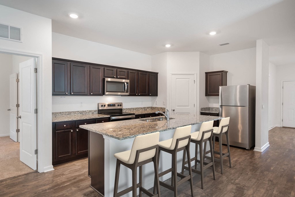 A kitchen with a granite countertop and stainless steel appliances.