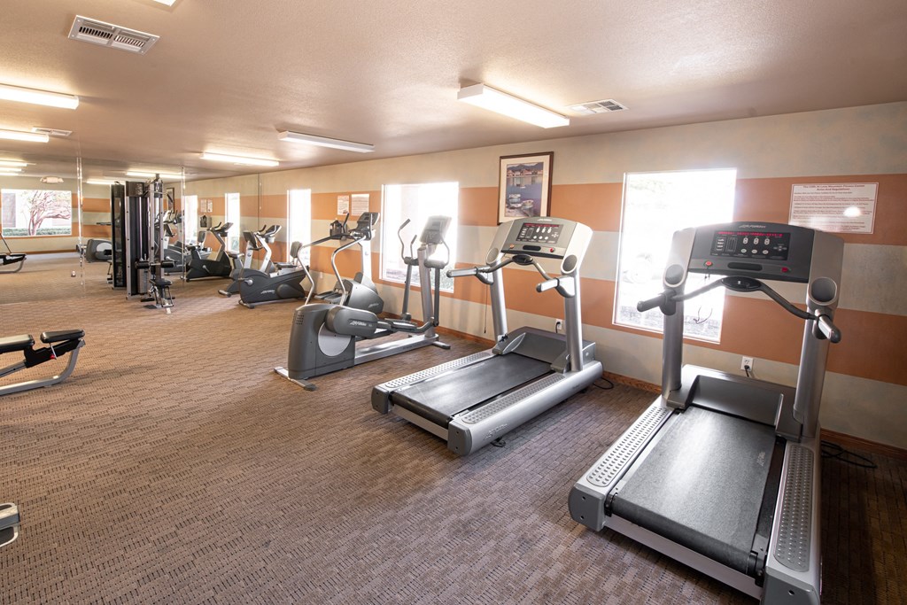 a gym with treadmills and other exercise equipment at the enclave at university crossings