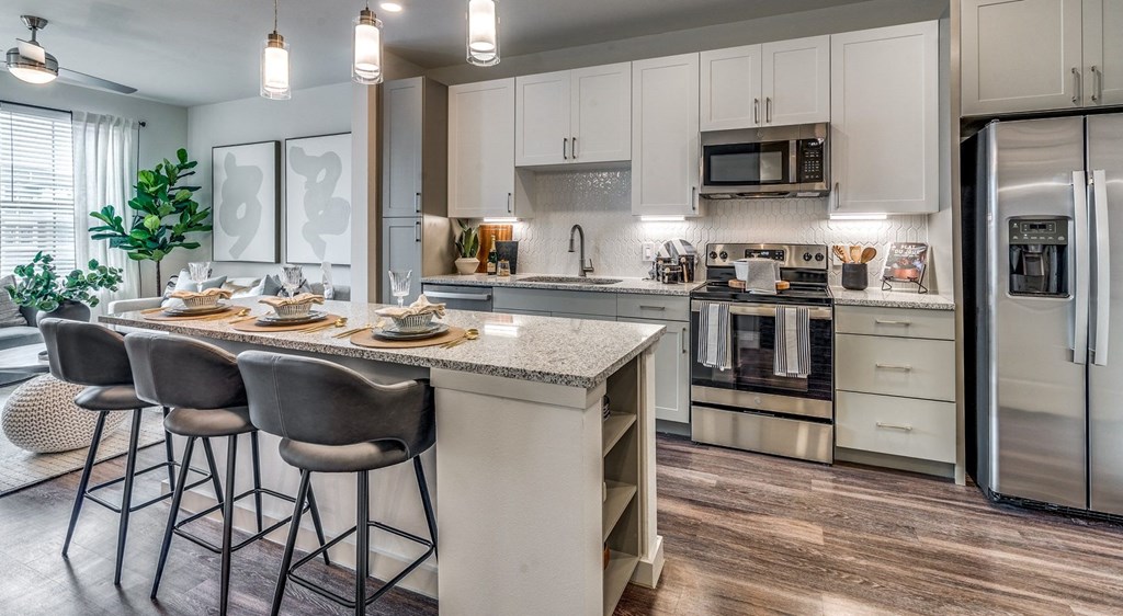 an open kitchen with a large island with stools
