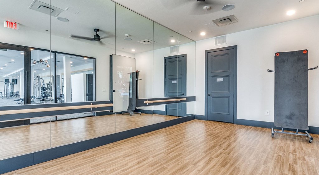the ballroom has a wood floor and mirrors on the wall