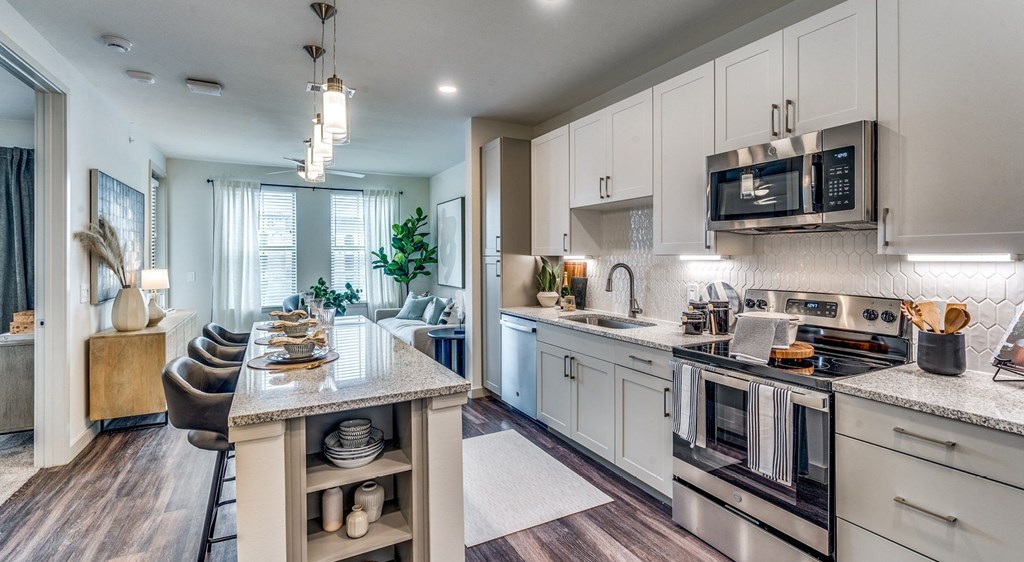 a kitchen with stainless steel appliances and a marble counter top