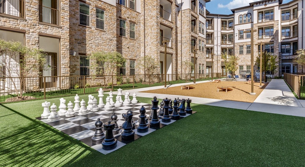 a large chess board in the middle of an apartment yard