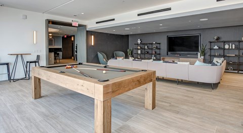 A room with a pool table and a couch.