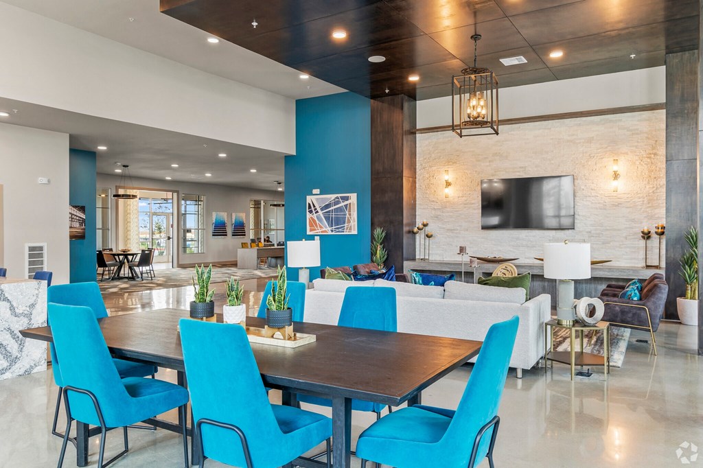 a dining area with a table and chairs and a large tv on the wall