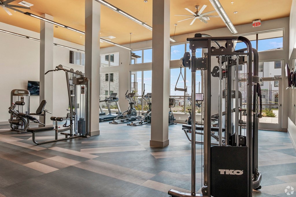 a fitness center with cardio machines and weights