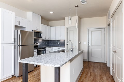 a kitchen with white cabinets and a granite counter top