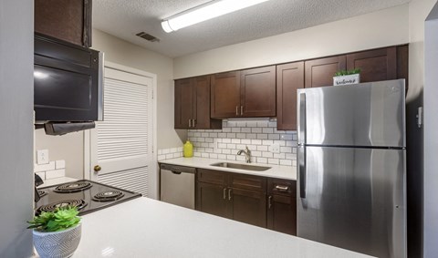 A kitchen with a stove top oven and a refrigerator.