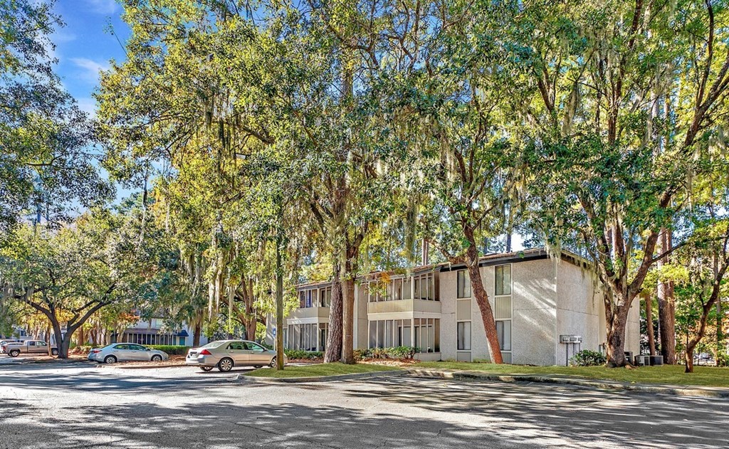 Greentree Apartments in Savannah, GA photo of a building with trees and cars parked in front of it