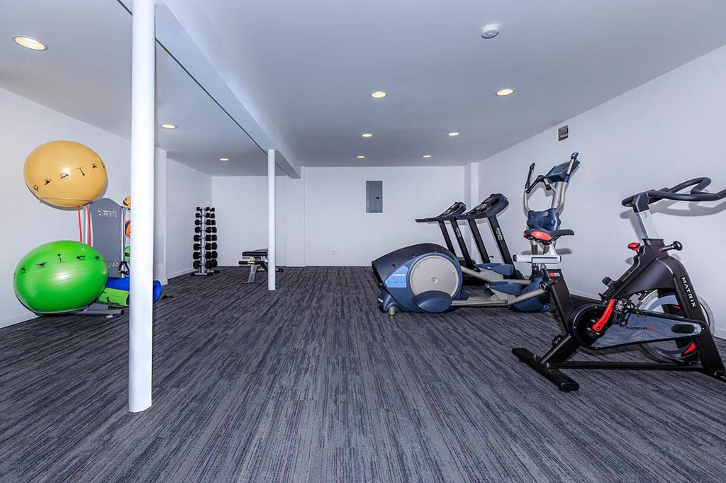 a gym with white walls and a green ball in the corner