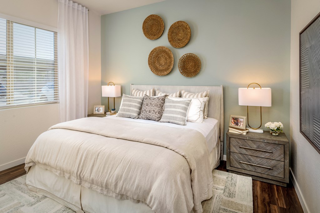 a bedroom with a bed and two lamps and a window