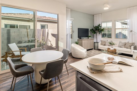 a living room and dining room with a table and a tv