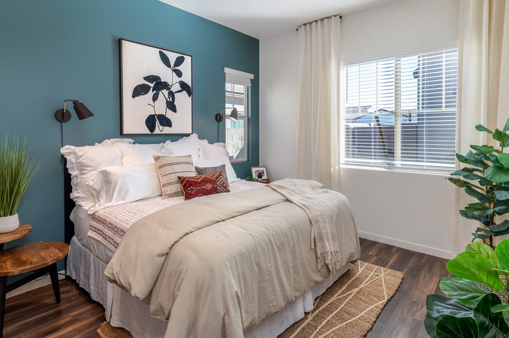 a bedroom with blue walls and a bed with white blankets and pillows