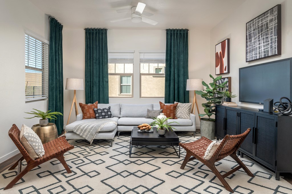 a living room with a couch and chairs and a tv