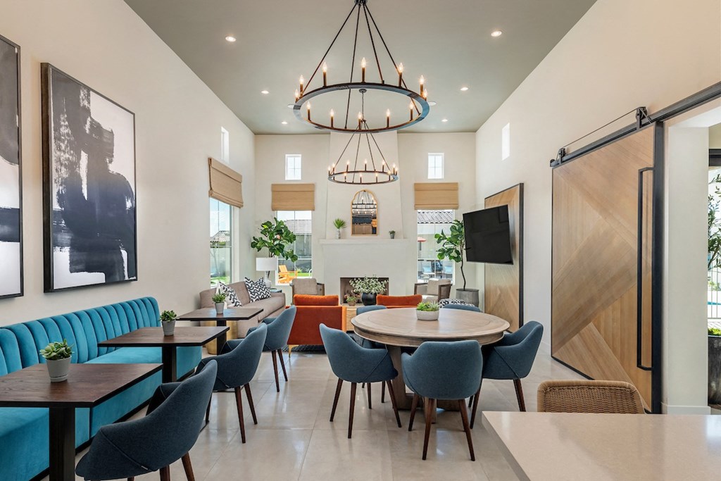 a dining room with tables and chairs and a living room with a fireplace