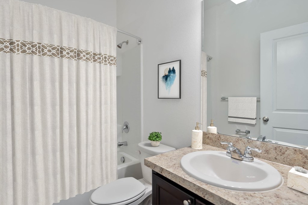A bathroom with a white toilet, a sink, and a shower curtain.