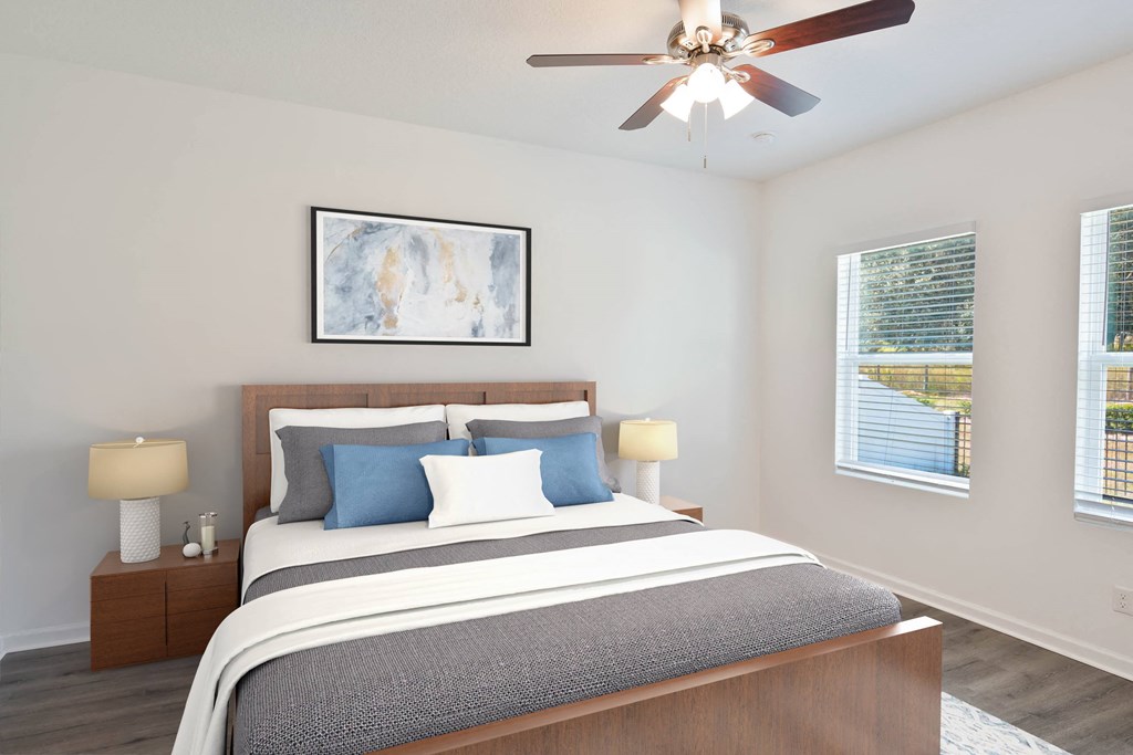 A bedroom with a large bed and a ceiling fan.