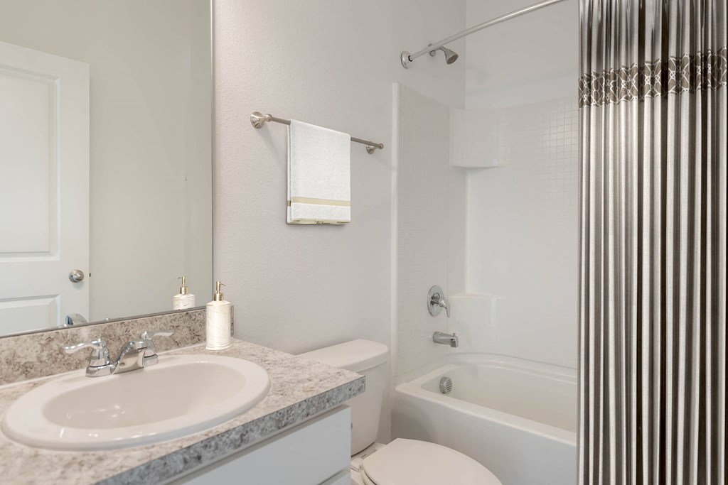 A white toilet sits next to a sink in a bathroom.