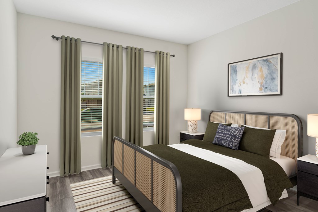 A bedroom with a large bed and a window with curtains.