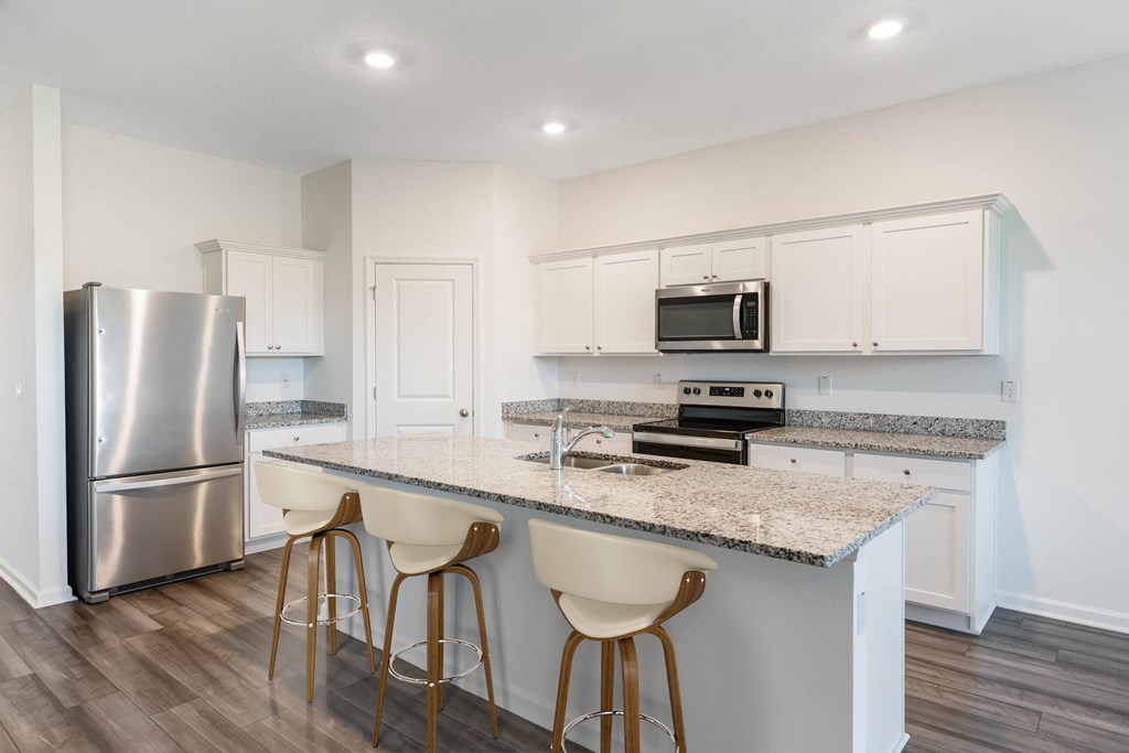 A kitchen with a granite countertop and white cabinets.