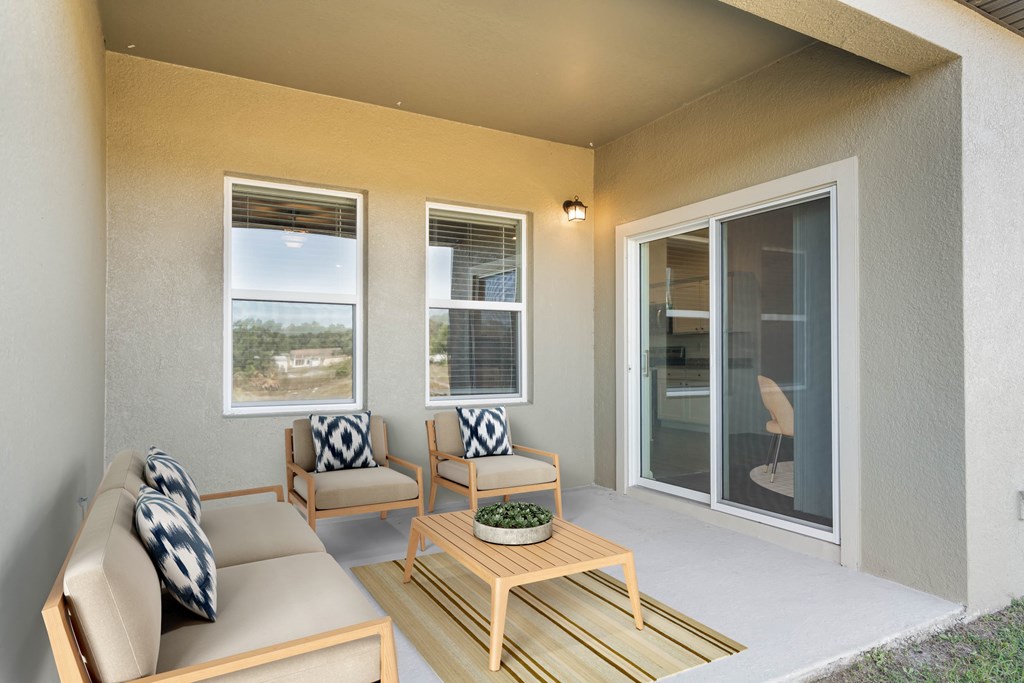 A patio with a couch, chairs, and a table.