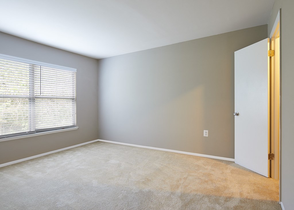 an empty room with a window and a door