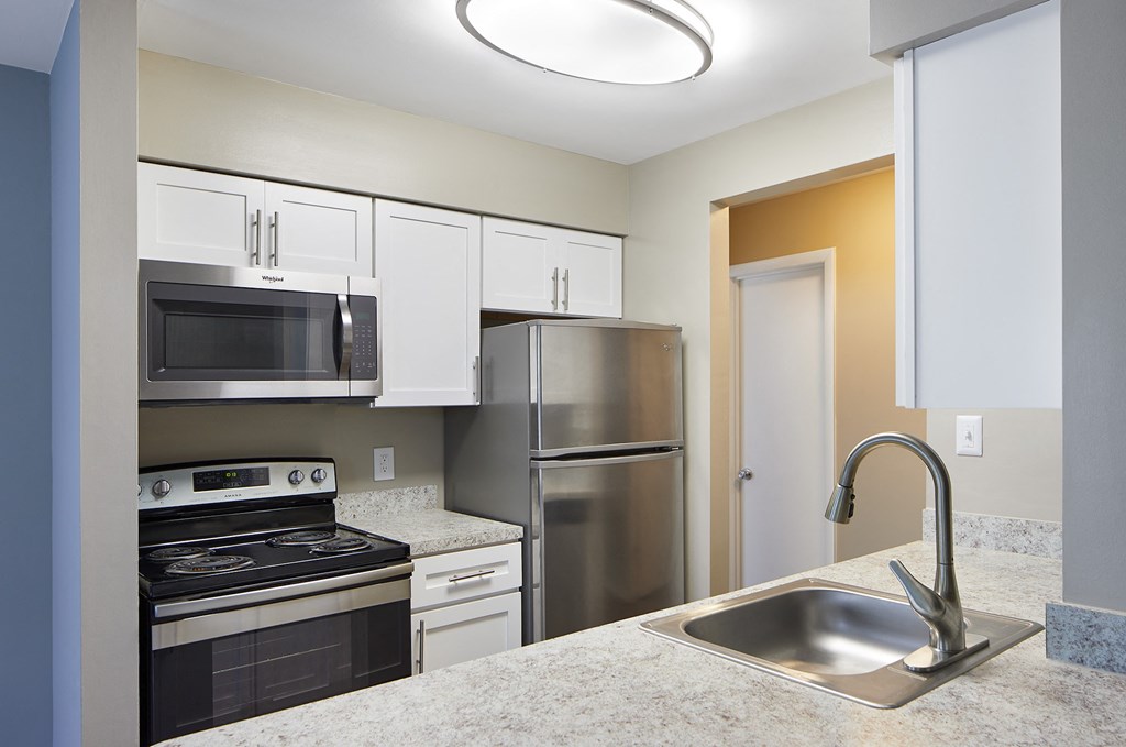 an empty kitchen with stainless steel appliances and a sink