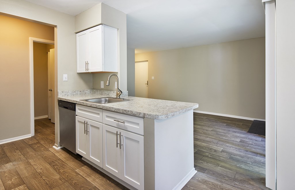 an empty kitchen with white cabinets and a sink