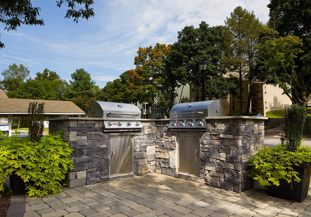 a stone outdoor kitchen with two grills