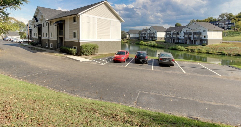 a row of cars parked in a parking lot near a body of water