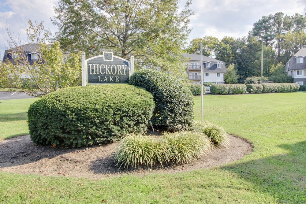the sign for hickory lake at the entrance to the park on the grass