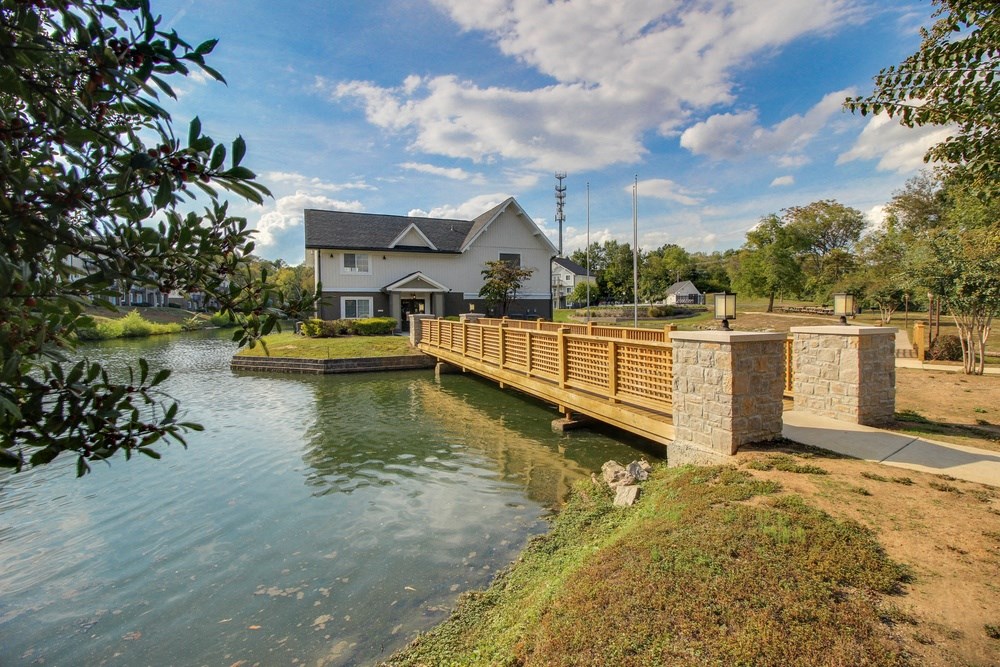 a bridge over a river with a house in the background
