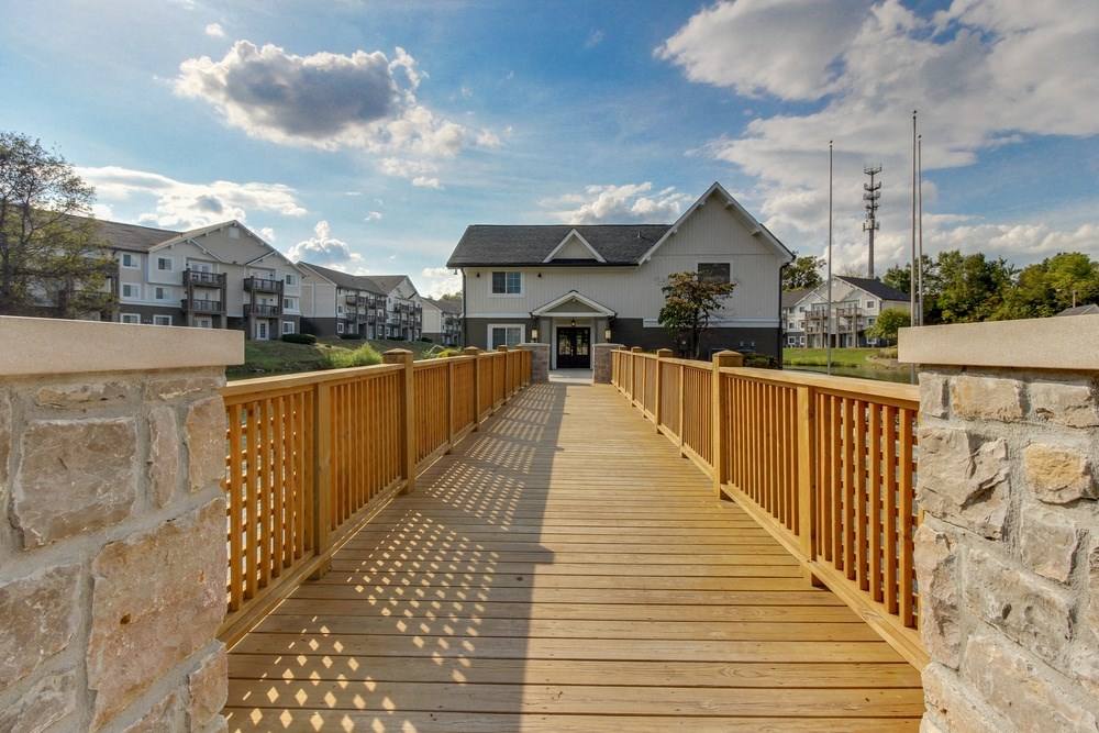 a wooden bridge with a house in the background