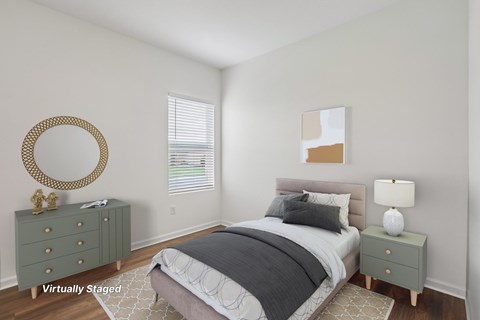 A bedroom with a bed, nightstand, and a mirror on the wall.