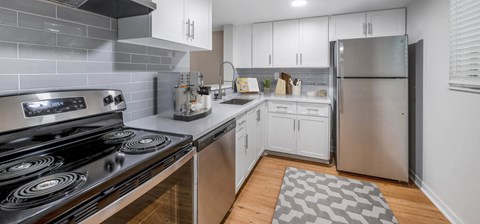 a kitchen with white cabinets and stainless steel appliances