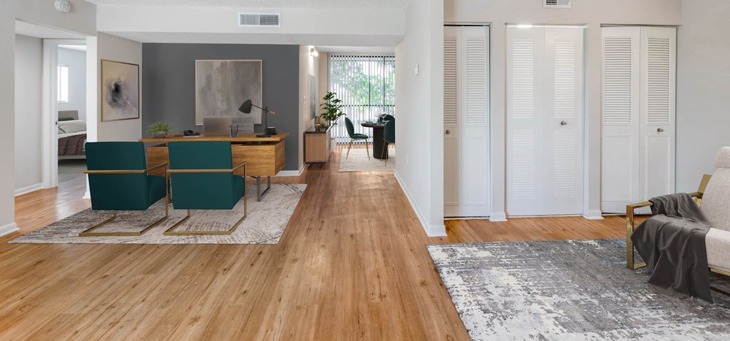 Apartment interior with hardwood floors, home office, dining area, and closet.