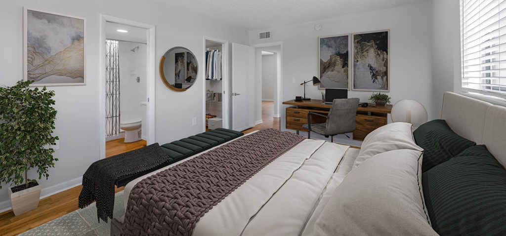 Bright bedroom with a workspace, ensuite bathroom, and walk-in closet.