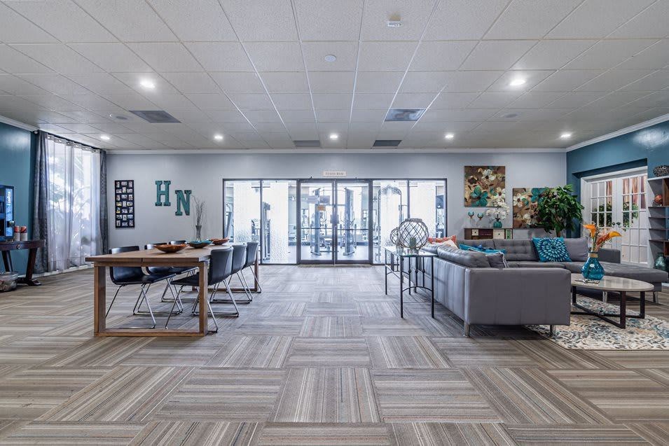 Community room with dining table, lounge area, and gym access.