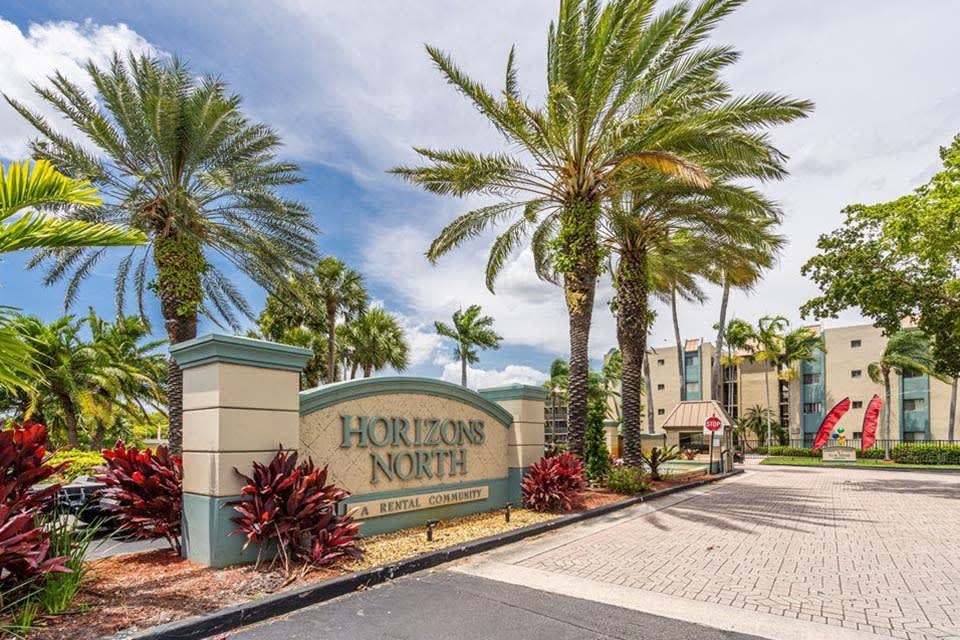 Entrance to Horizons North rental community with palm trees.