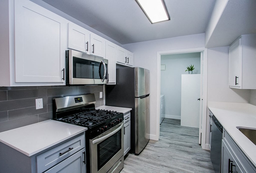 a kitchen with white cabinets and stainless steel appliances