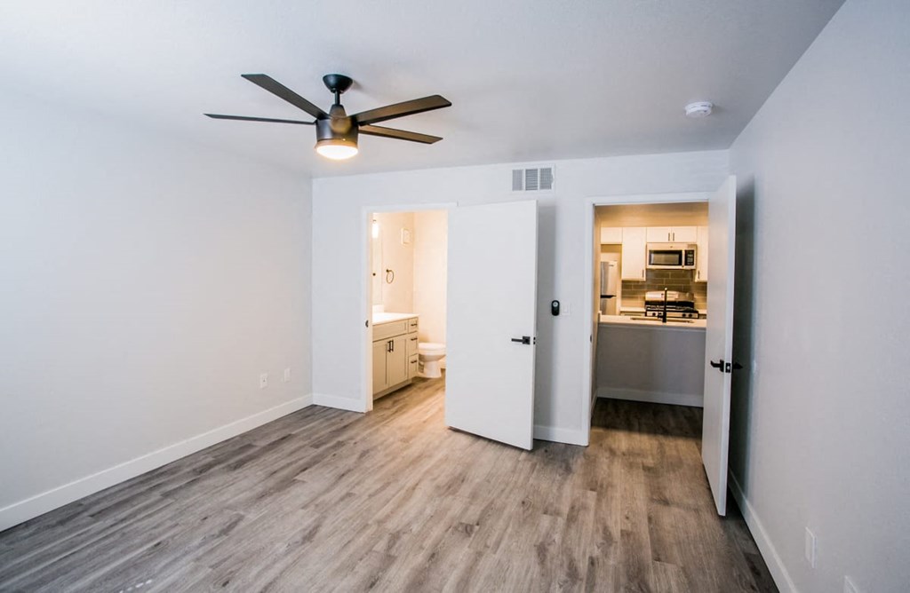 a bedroom with hardwood floors and white walls