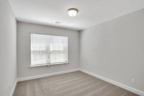 Harris Trail Luxury Townhomes for rent Richmond Hill, GA photo of bedroom with large window and plush carpeting